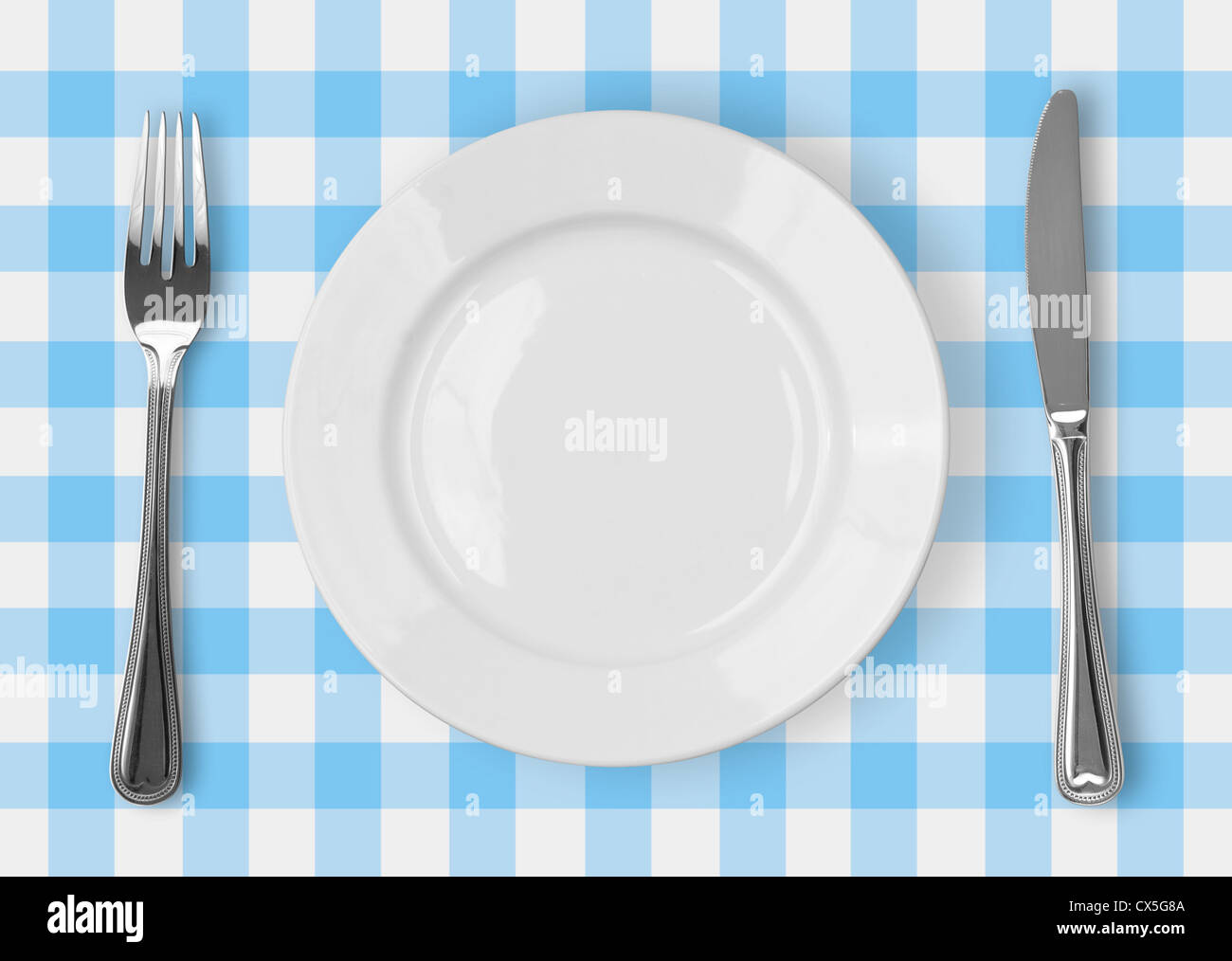 Coltello, piastra bianca e la forcella sul blu tovaglia controllati Foto Stock