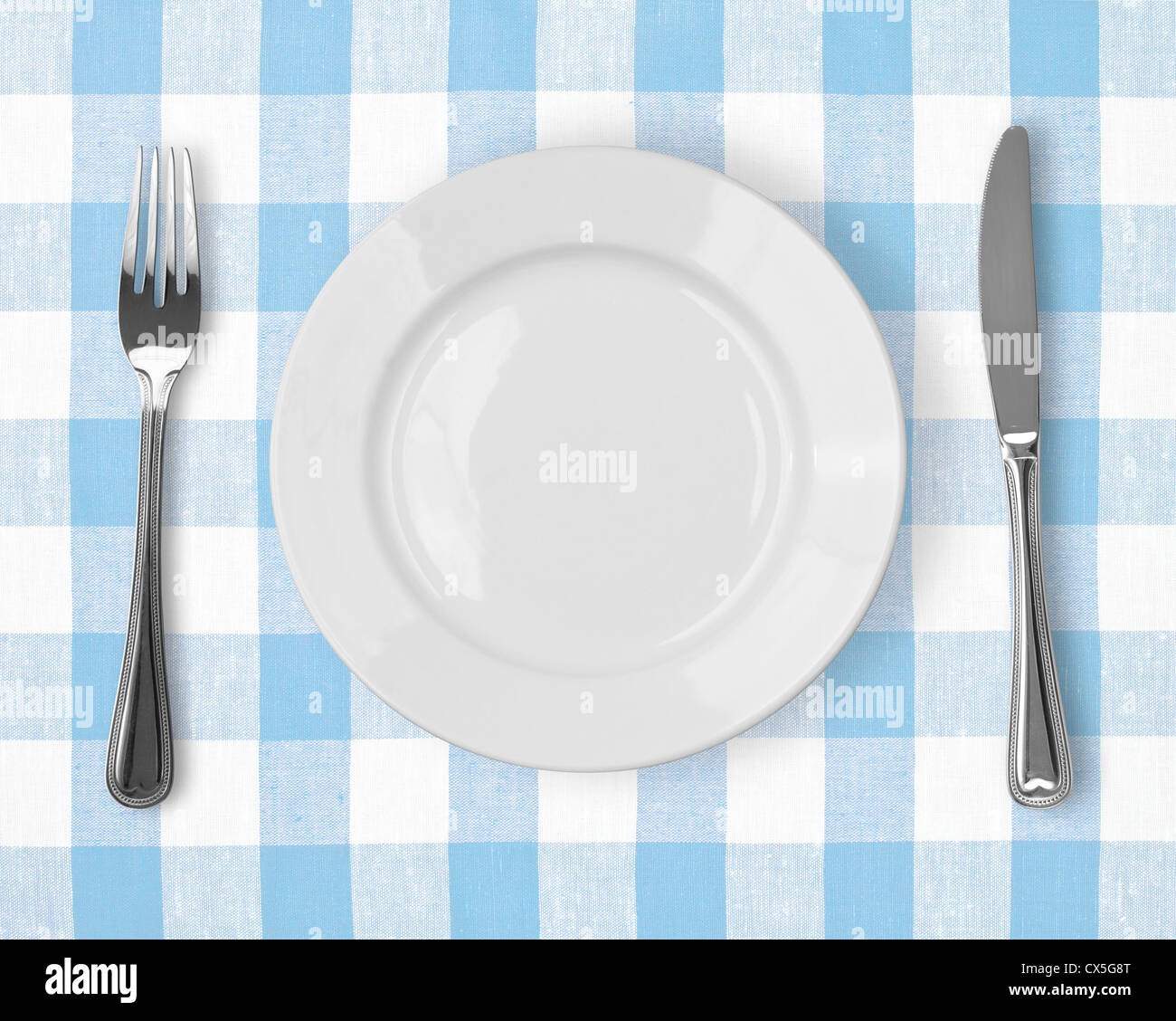 Coltello, piastra bianca e la forcella sul blu tovaglia controllati Foto Stock