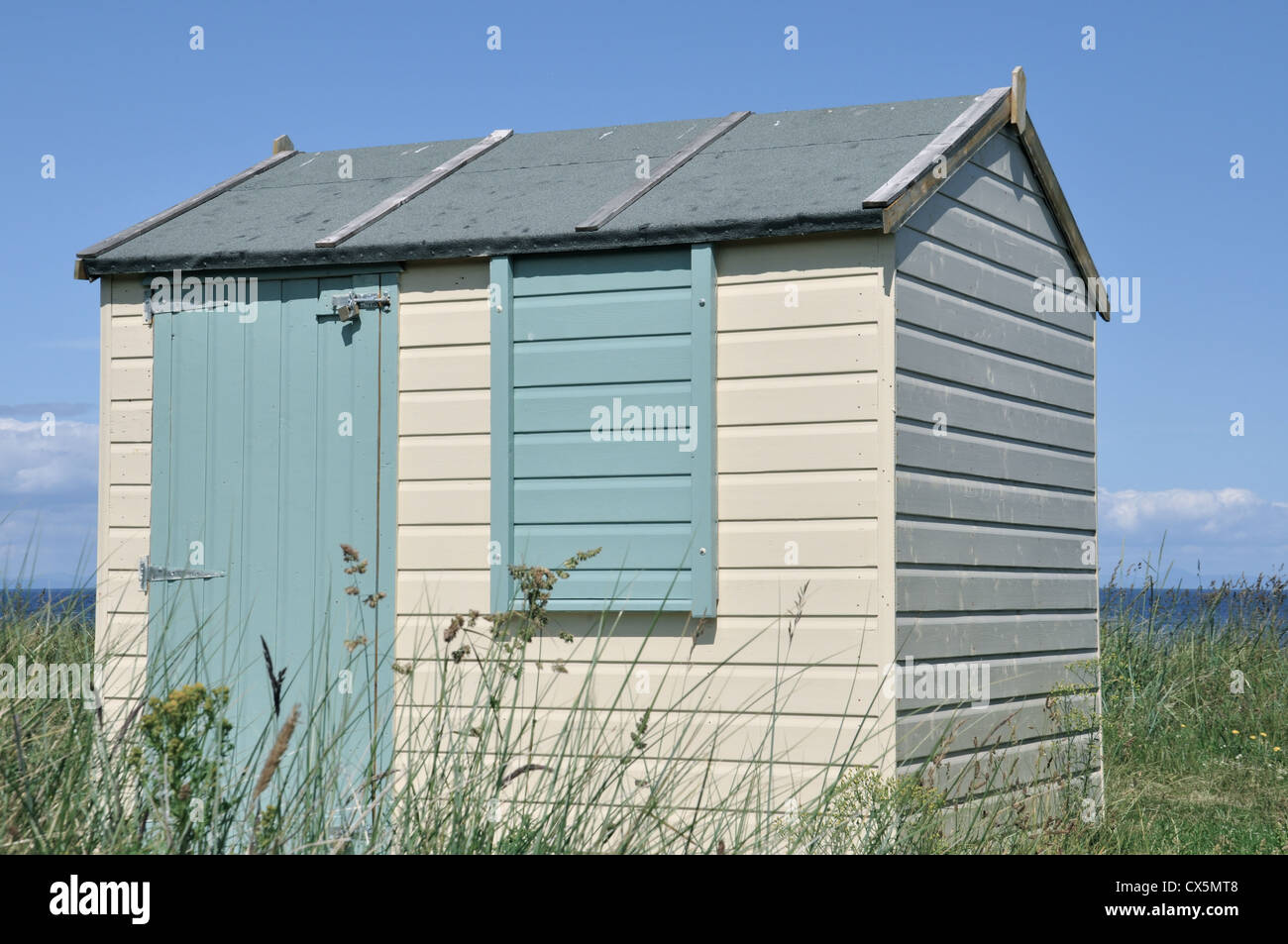 Cabine sulla spiaggia, sotto il sole a Hopeman, Scozia settentrionale Foto Stock