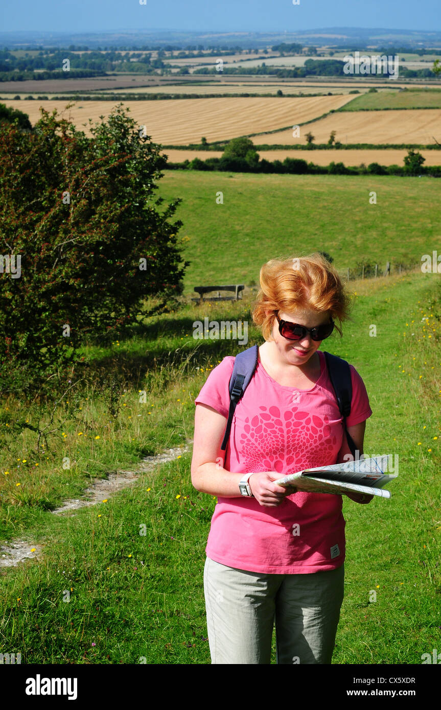 Donna che guarda la mappa nella campagna vicino a la Ridgeway, Chilterns, Oxfordshire, Regno Unito Foto Stock
