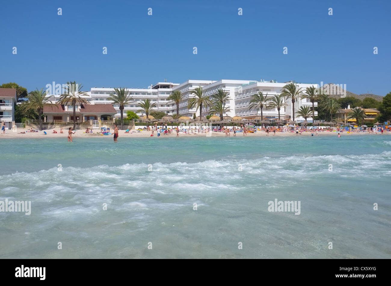 Una spiaggia vacanze scena sull'isola di Maiorca guardando dal mare per gli alberghi e la spiaggia Foto Stock