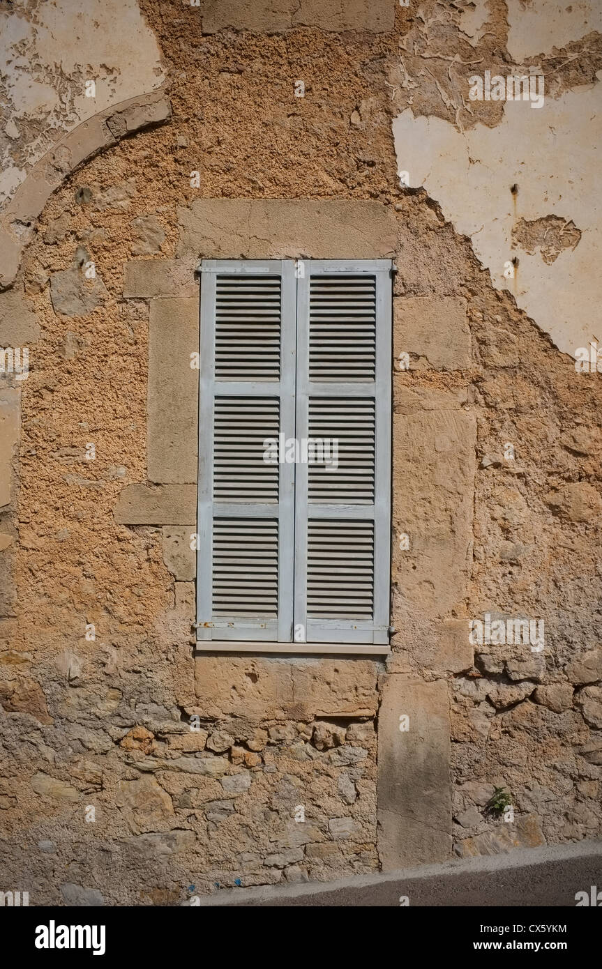 Una tradizionale finestra ritagliata in Maiorca con un vecchio muro incrinato esposizione di mattoni Foto Stock