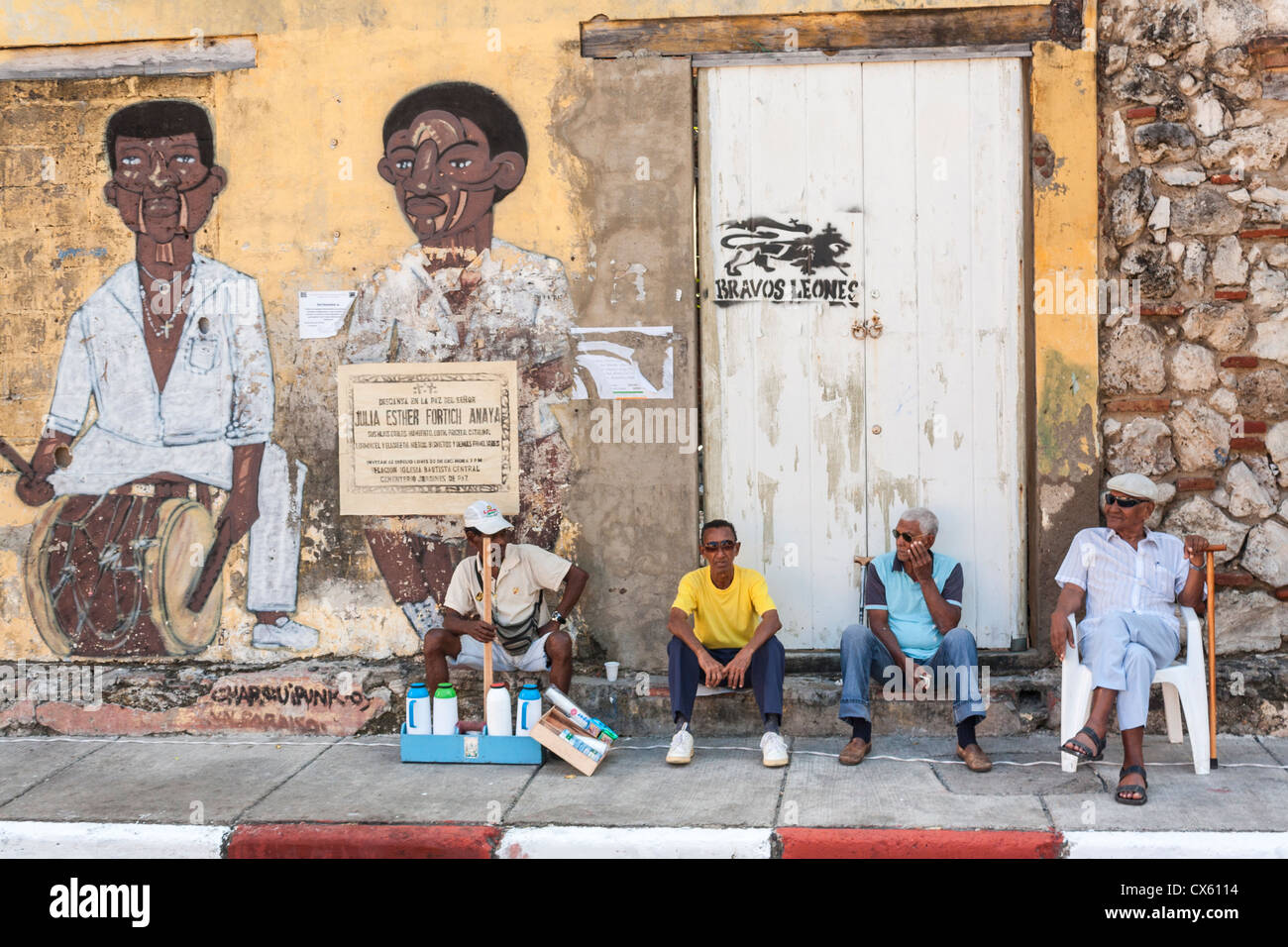 Gli uomini seduti contro un muro, Cartagena, Colombia Foto Stock