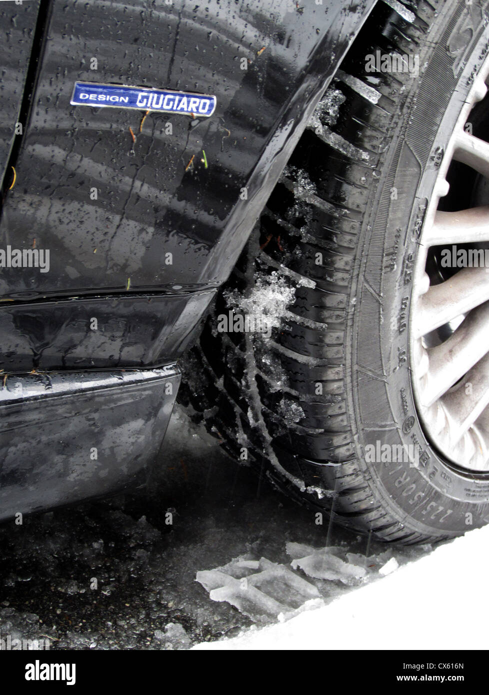 Pneumatici invernali su una famiglia di guida auto nella neve. Questo British Alfa è nelle Alpi Svizzere a freddo dei pneumatici, nota il battistrada profondo Foto Stock