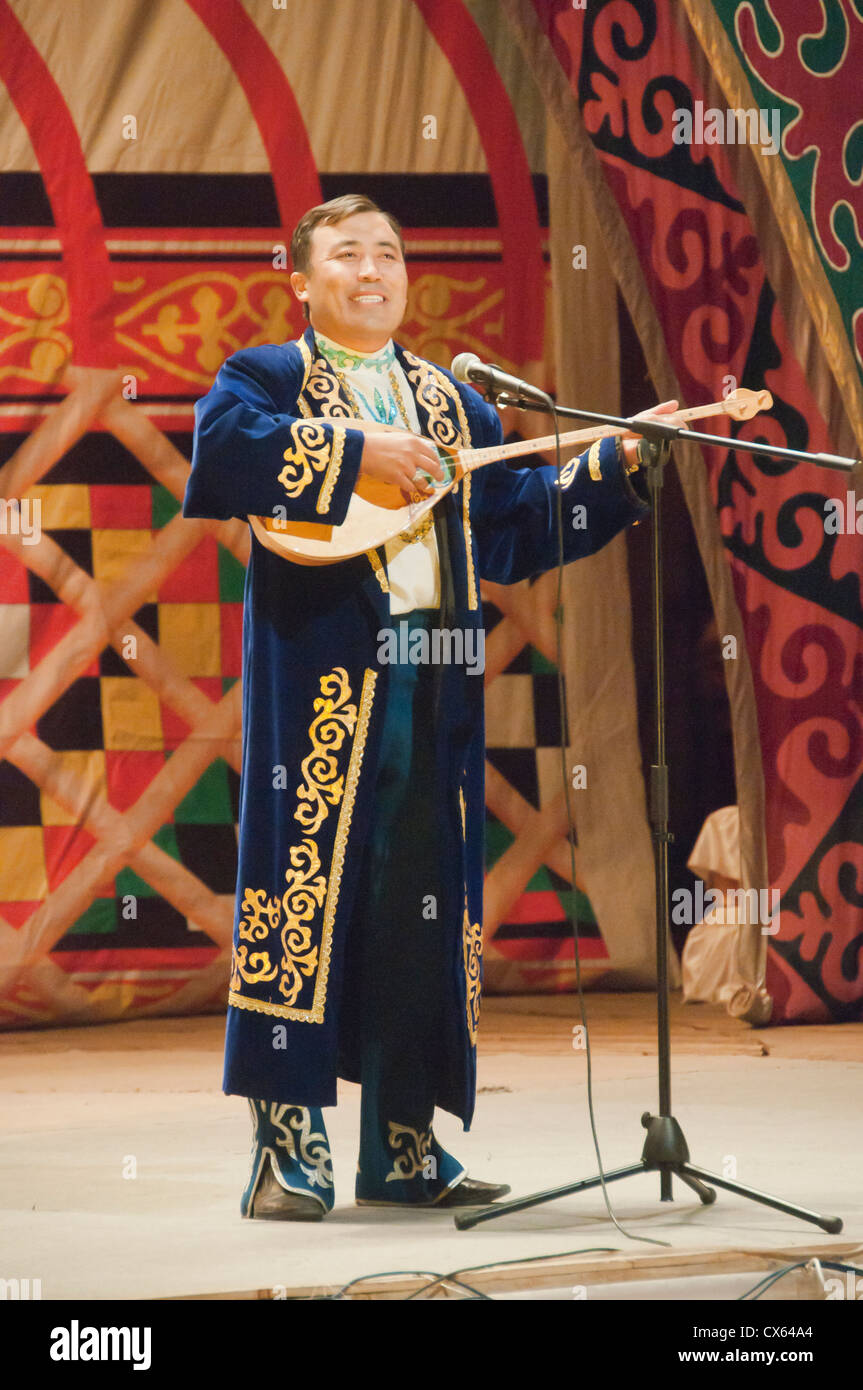 Musicista kazaka riproduzione di un tradizionale dombra strumento a corda in Bayan-Ölgii in Mongolia occidentale Foto Stock