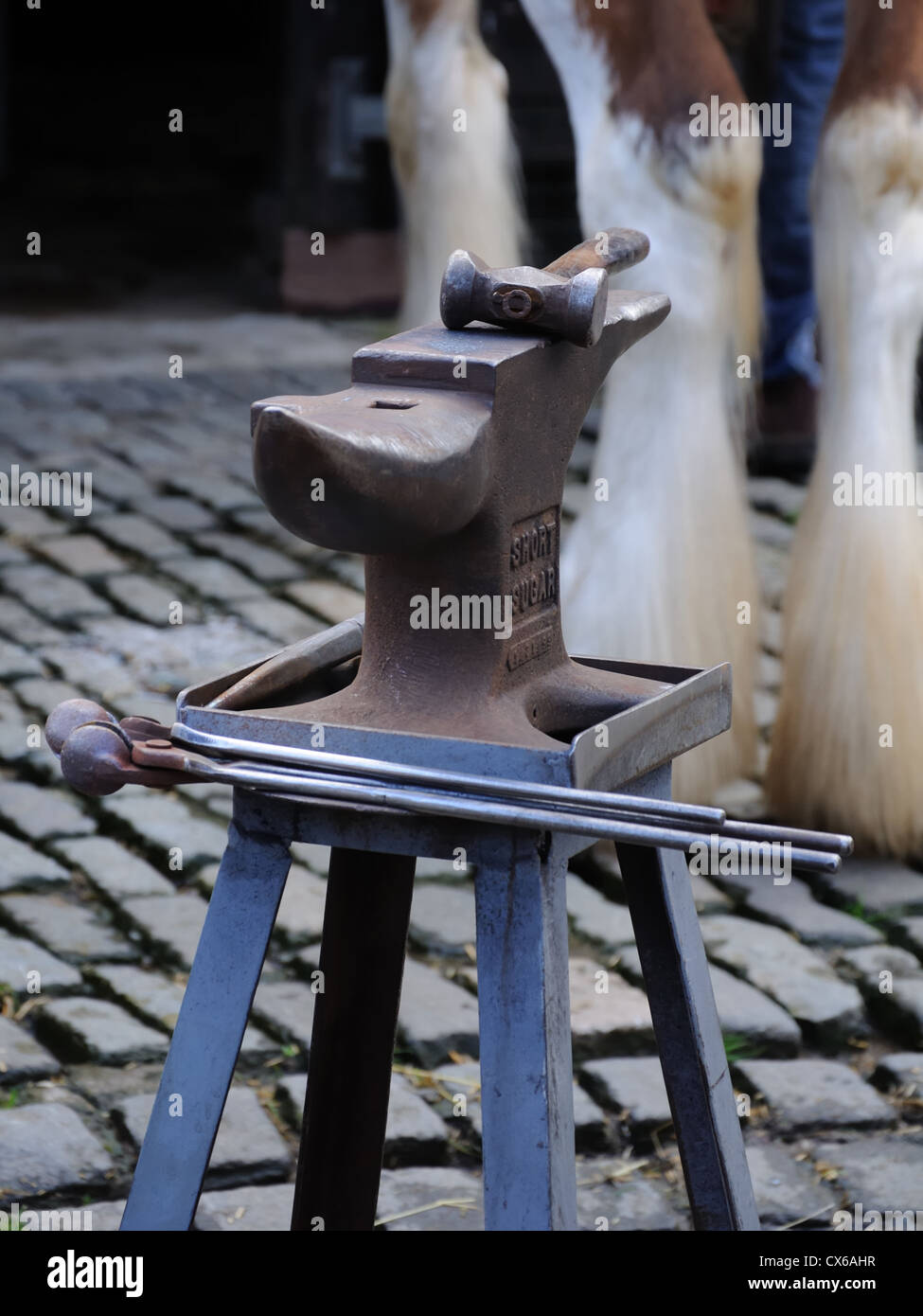 Maniscalchi incudine, gli strumenti e le gambe di un cavallo Clydesdale. Foto Stock