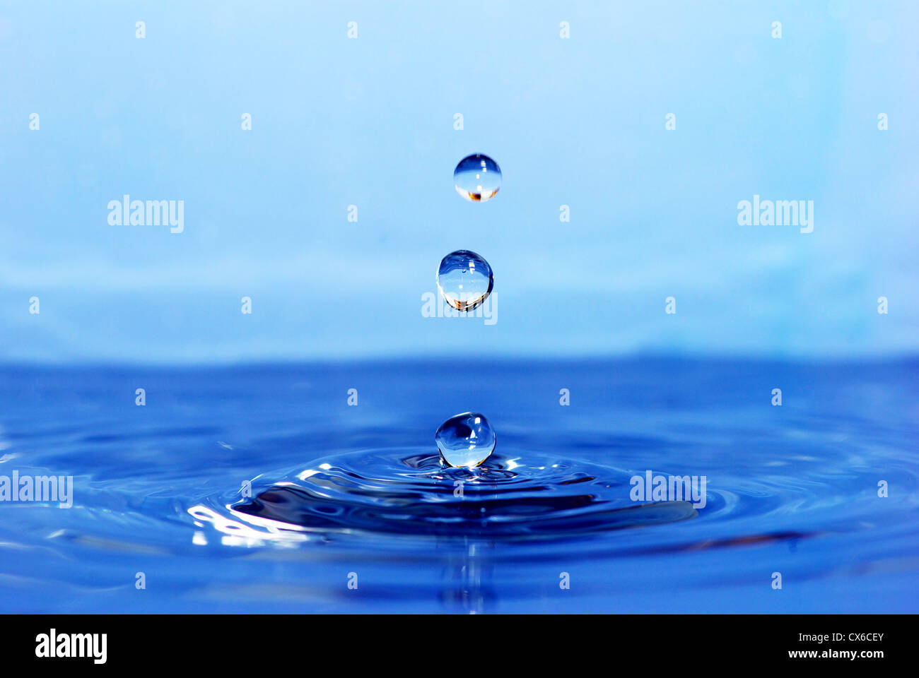 La rotonda trasparente goccia di acqua cade verso il basso Foto Stock