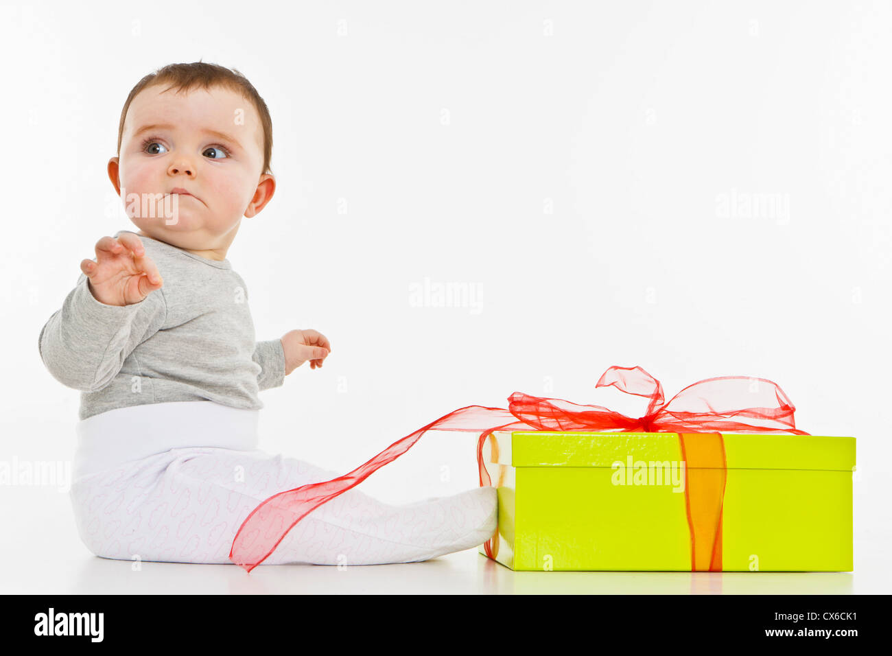 Un bambino ragazza seduta con un presente Foto Stock