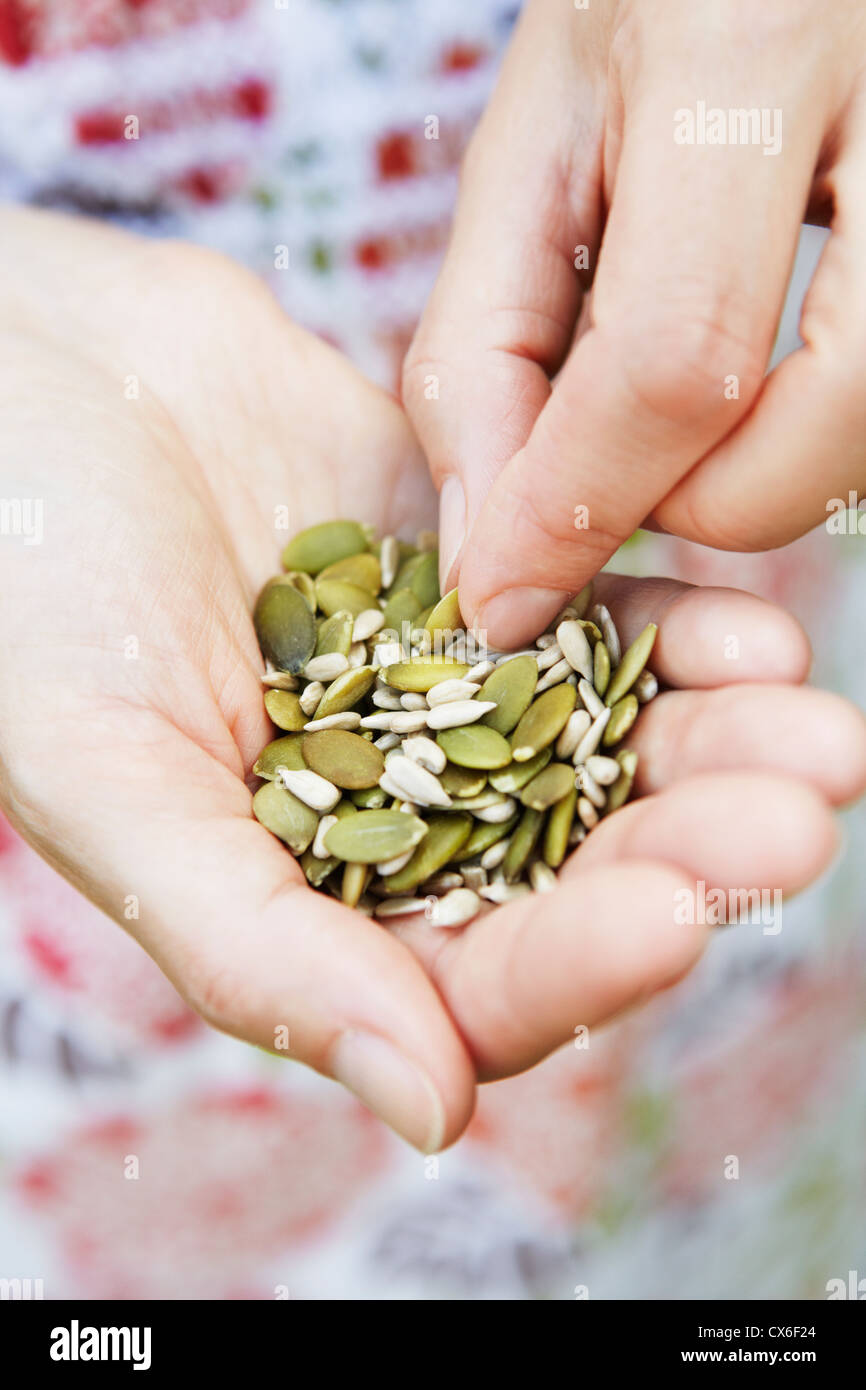 Close up della donna a mangiare una manciata di sementi sane Foto Stock