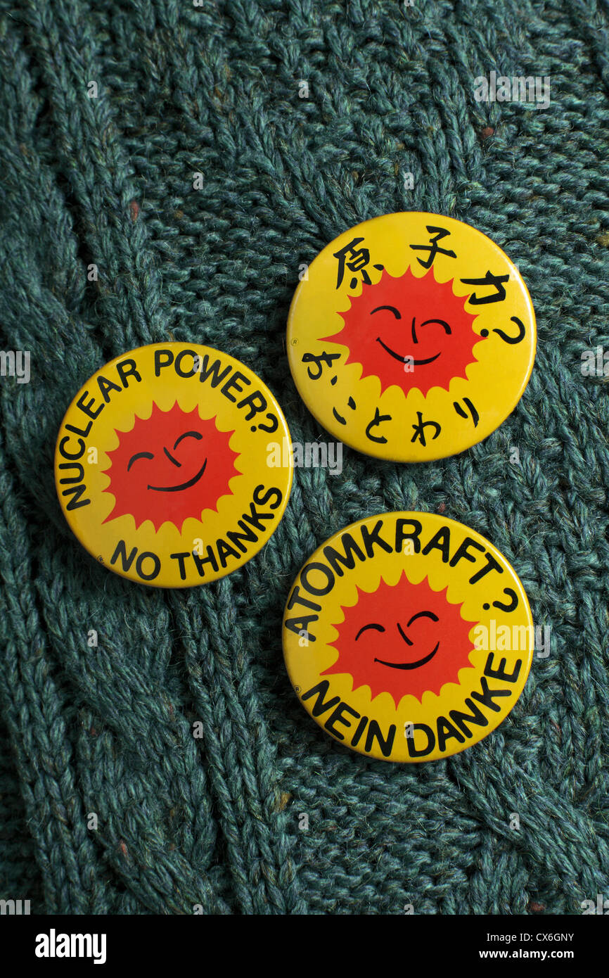 Persona che indossa tre anti-nucleare, badges lettura "Energia nucleare? No grazie" in inglese, tedesco e giapponese. Foto Stock