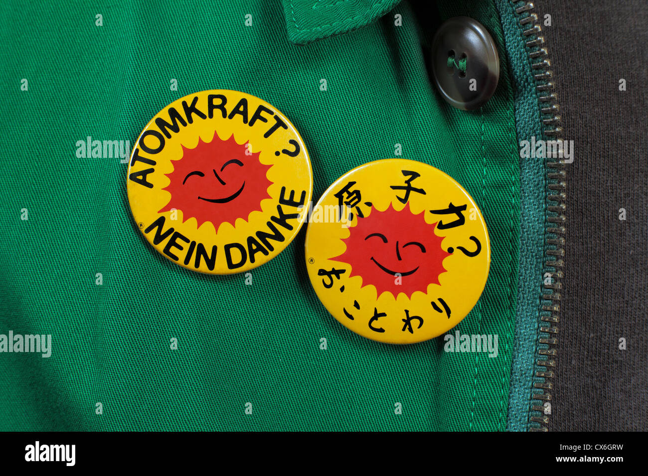 Persona che indossa due anti-nucleare, badges lettura "Energia nucleare? No grazie" in tedesco e giapponese. Foto Stock
