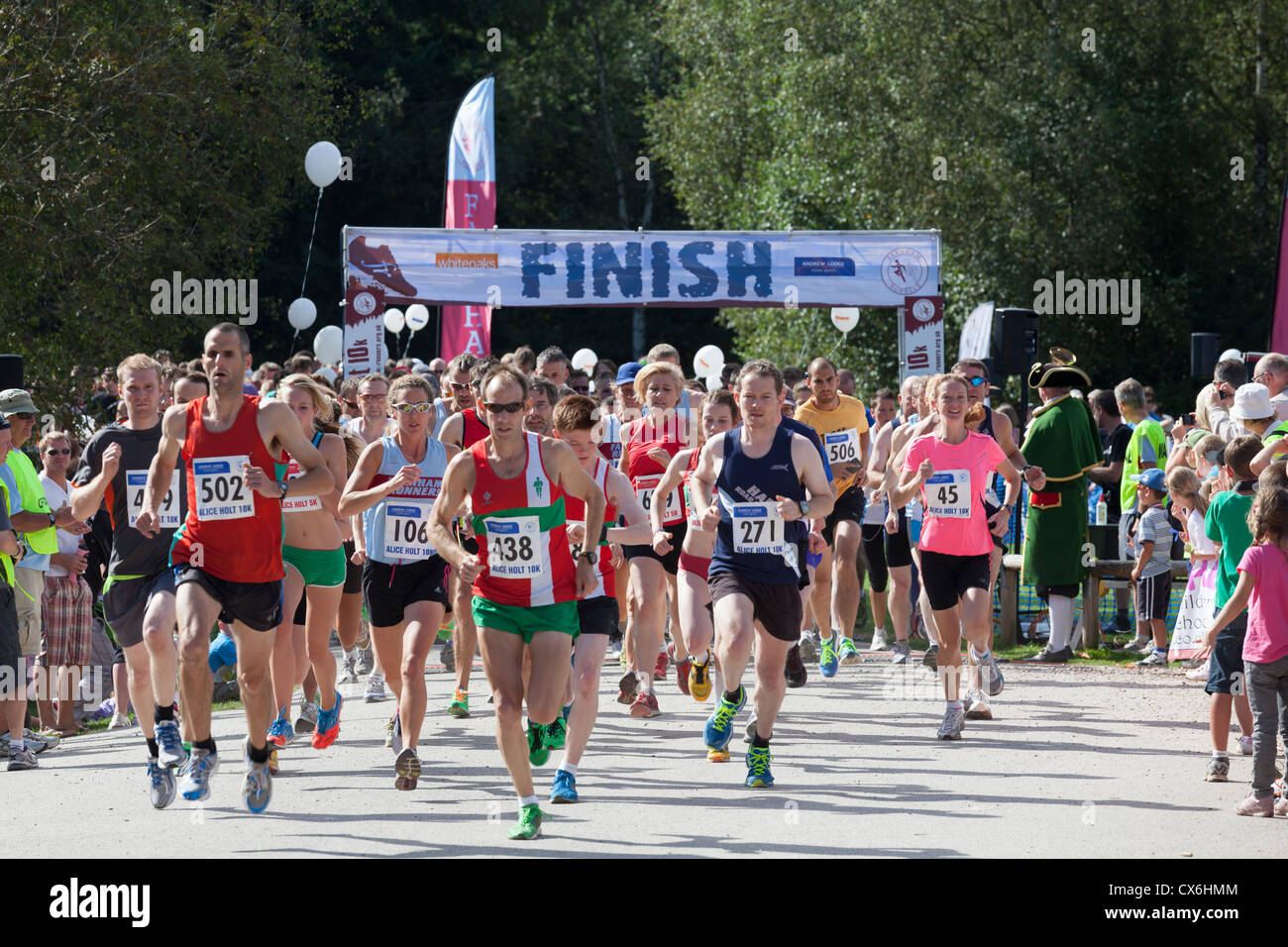 Guide di scorrimento a partire da 10k e 5k correre a Alice Holt foresta con segno di finitura. Foto Stock