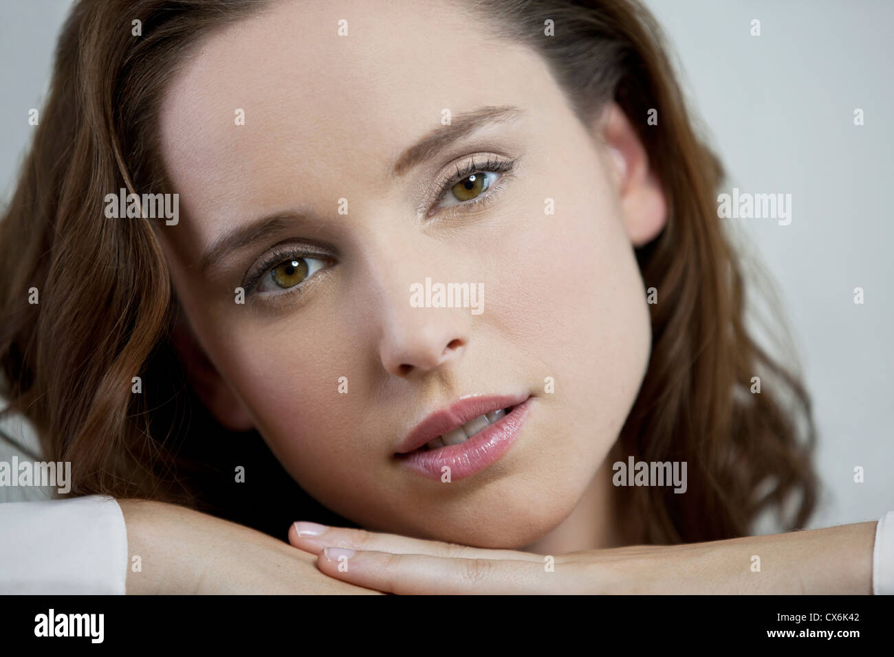 Una giovane donna in appoggio la sua testa sulle mani Foto Stock