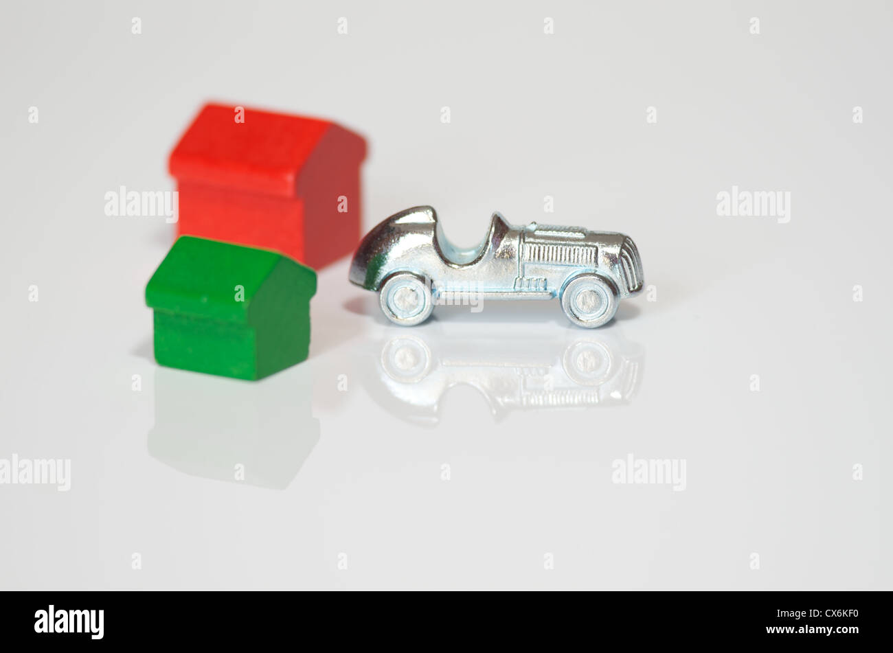 Auto di monopolio e casa isolata su sfondo bianco con la riflessione Foto Stock