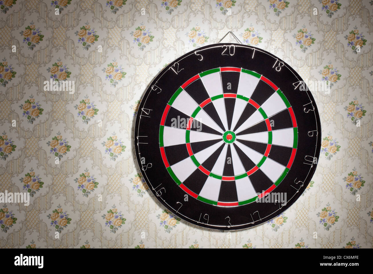 Un dartboard appeso a una parete tappezzate Foto Stock