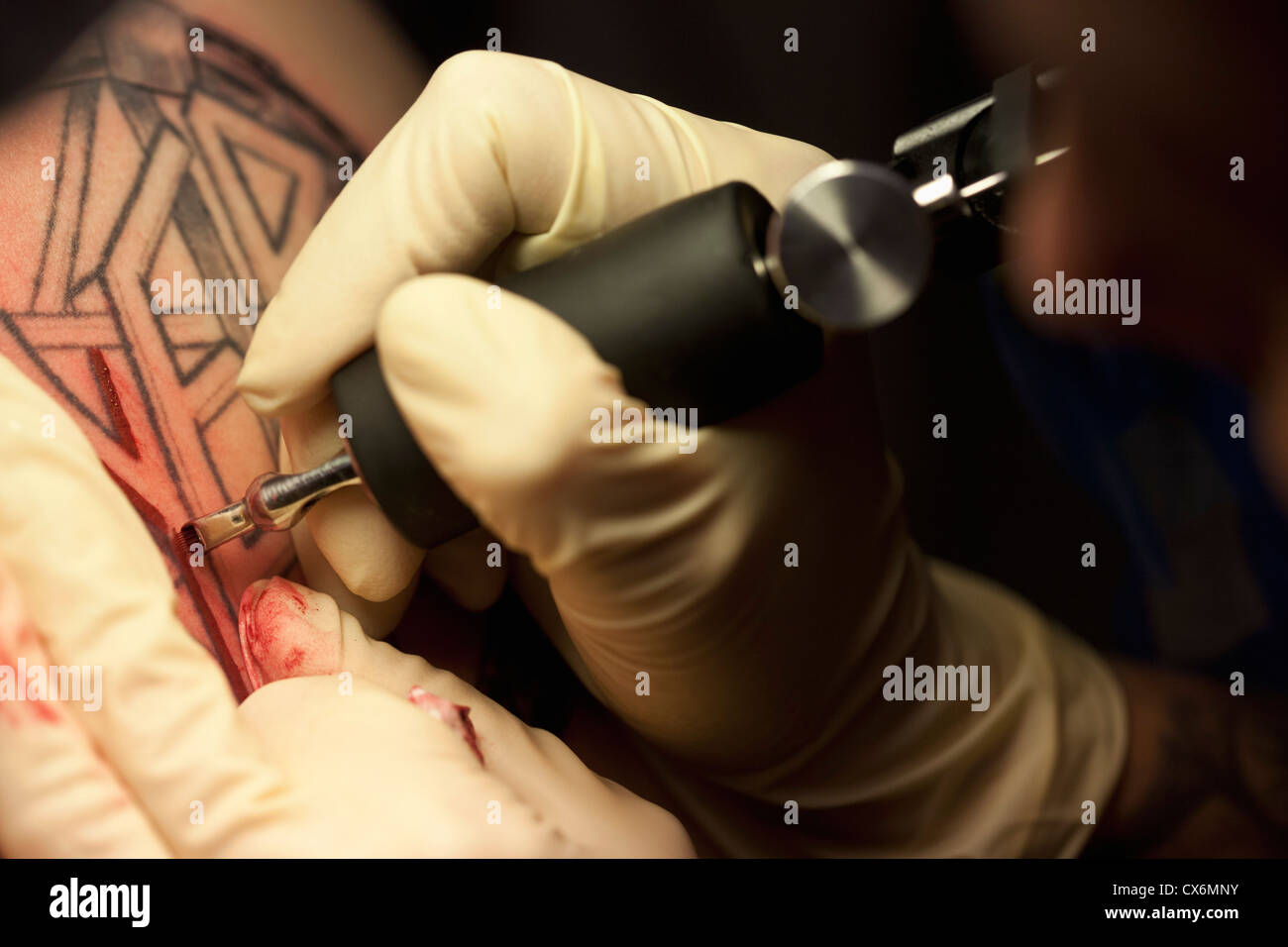 Close-up di un tatuaggio artista tatuaggio un disegno sulla pelle umana Foto Stock