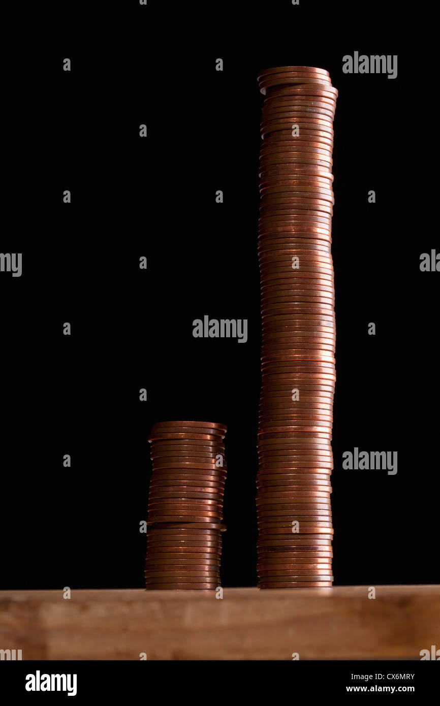 Due dimensioni diverse pile di monete di rame a fianco a fianco Foto Stock