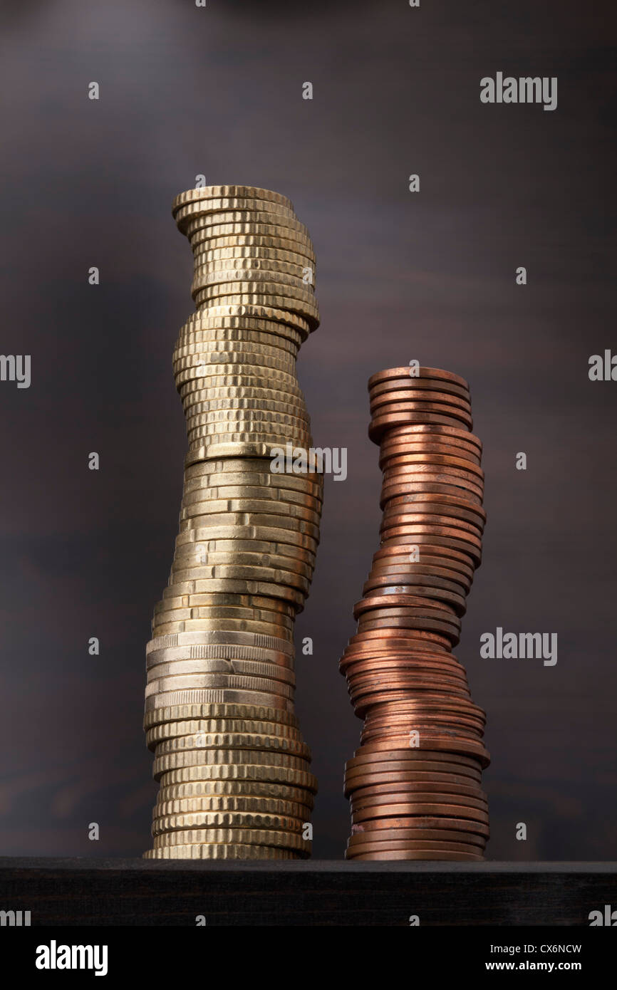 Una pila di oro monete in euro accanto a una pila di rame delle monete in euro Foto Stock
