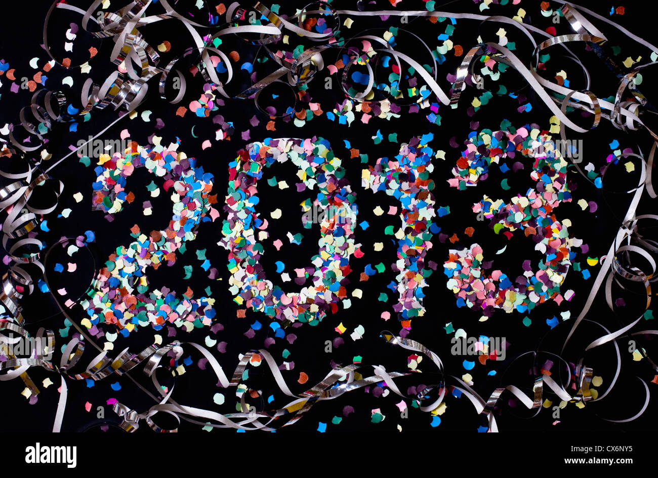L'anno 2013 sillabato con coriandoli e circondato da stelle filanti Foto Stock