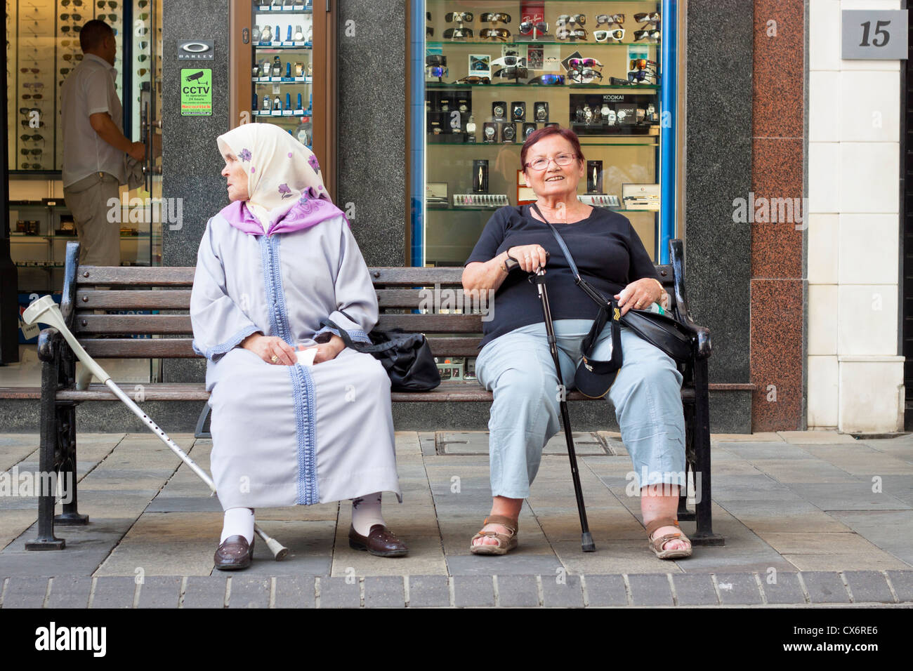 Le donne anziane seduta sul banco di lavoro. Main Street, Gibilterra, Regno Unito. Foto Stock