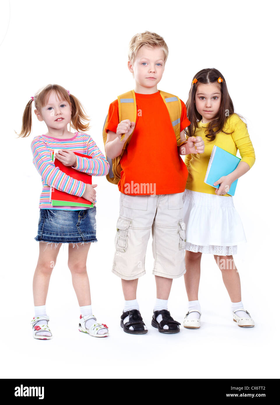 Un gruppo di bambini della scuola di isolati su sfondo bianco guardando con fiducia alla fotocamera Foto Stock