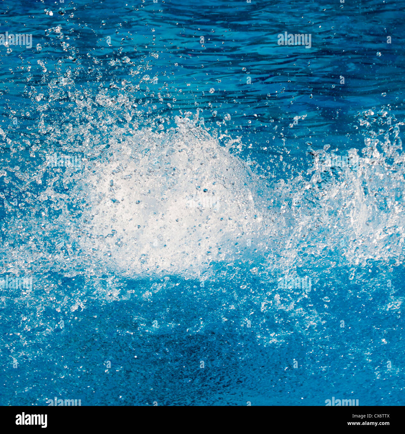 Acqua pura trasparente splash su un blu brillante superficie. Foto Stock