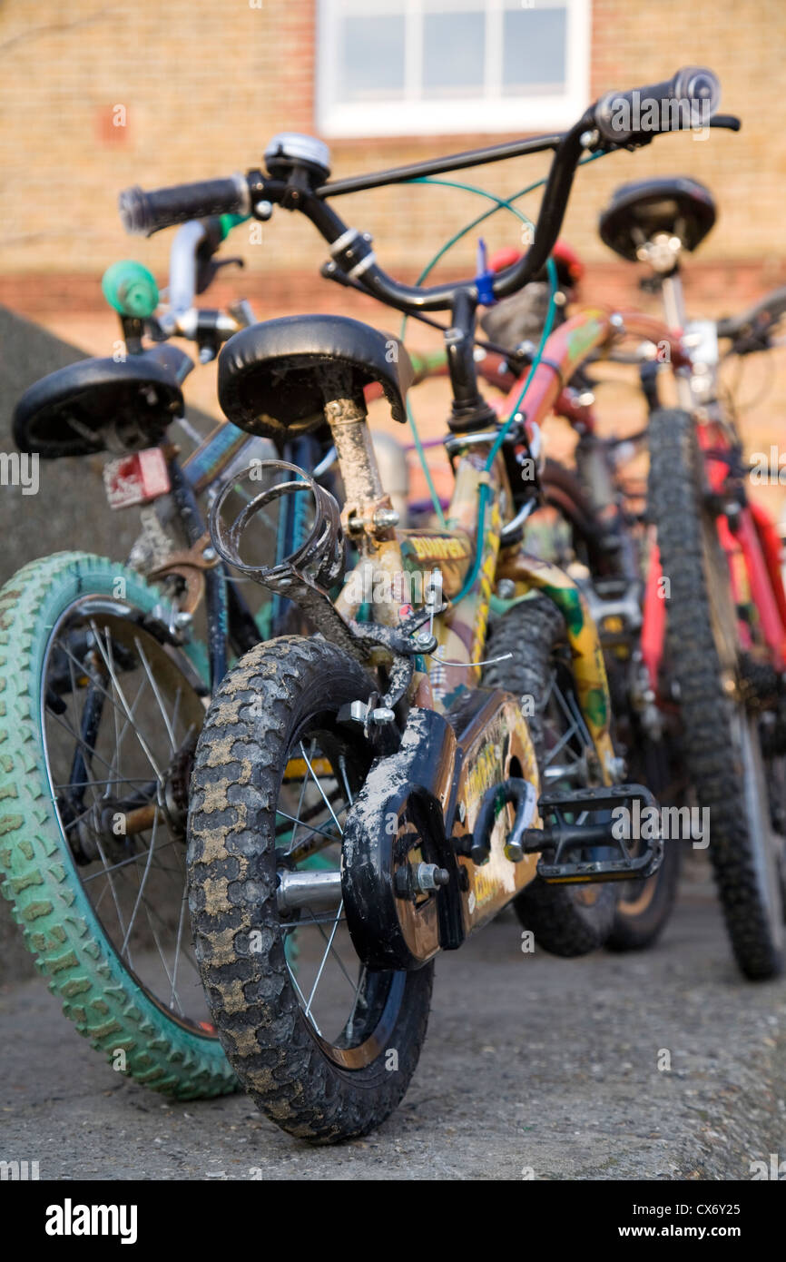 Biciclette da bambino, sostenuto contro un muro, Kent, England, Regno Unito Foto Stock