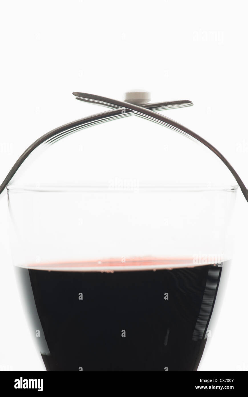 Medicina sulla parte superiore di un bicchiere di vino rosso Foto Stock