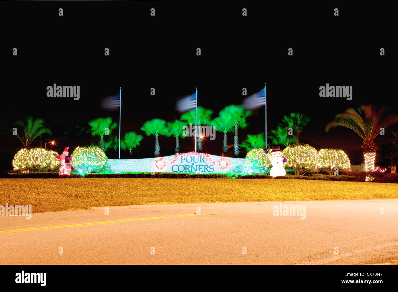 Scena notturna di ingresso a quattro angoli, Davenport, Florida che è illuminato da decorazioni di Natale. Le bandierine americane sono Foto Stock