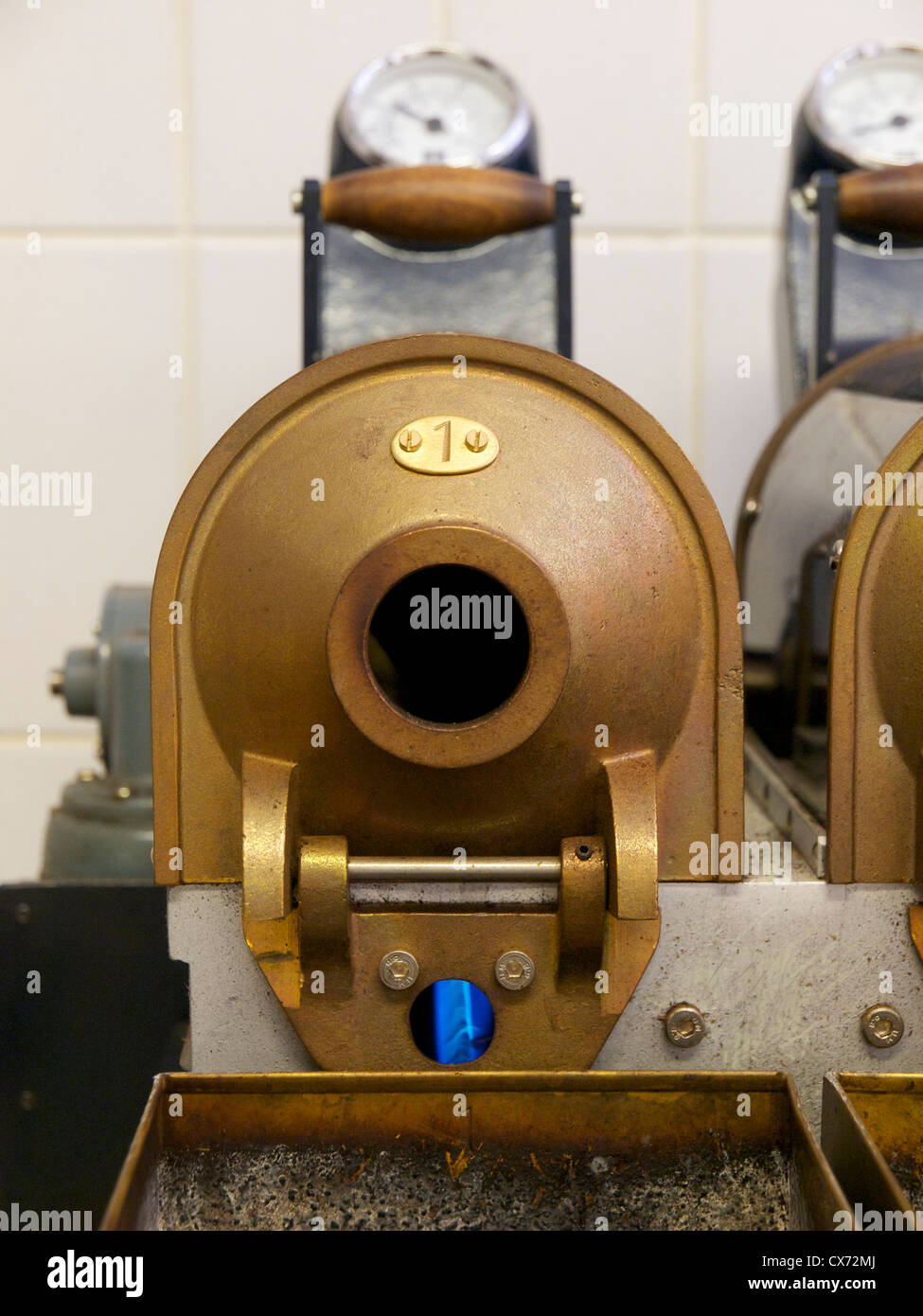 Miniatura chicco di caffè tostatura di macchina per arrostire i campioni prelevati da un lotto considerevole di fagioli con fiamma a gas visibili. Foto Stock