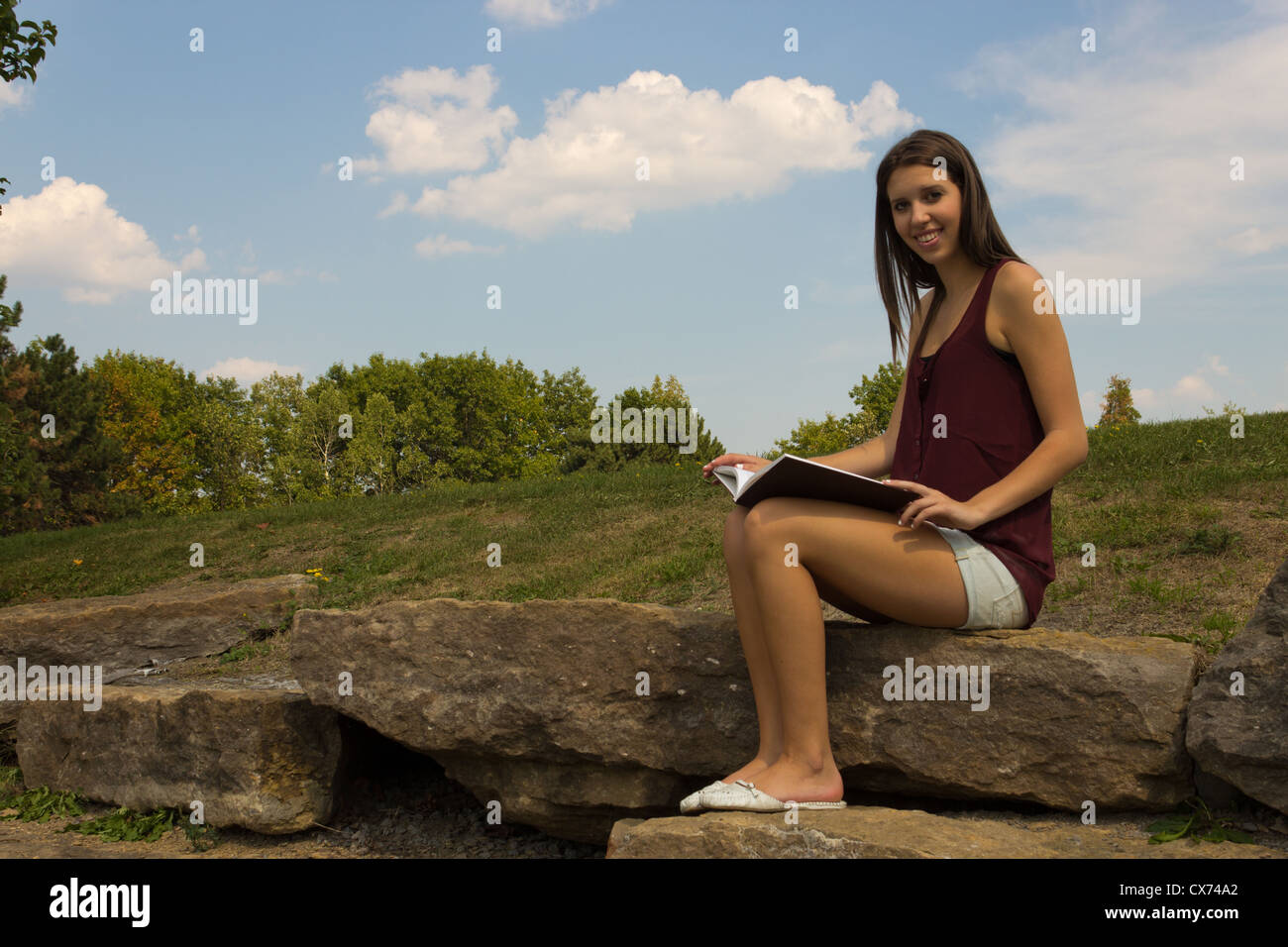 Pretty girl leggendo nel parco - copyspace Foto Stock