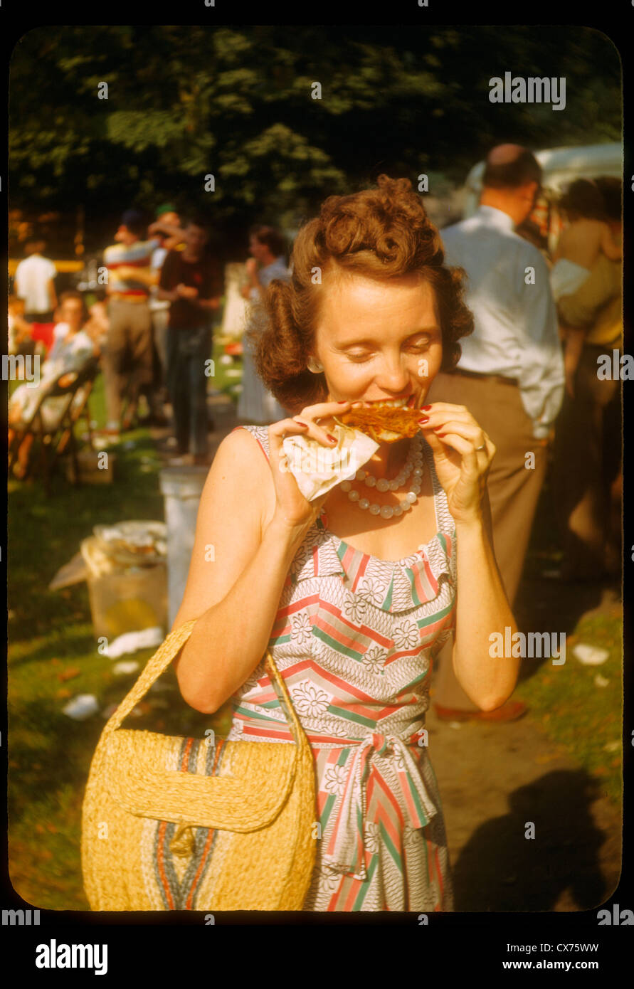 Foto a colori donna mangiare pollo alla moda picnic 1940s redhead sacchetto kodachrome Foto Stock