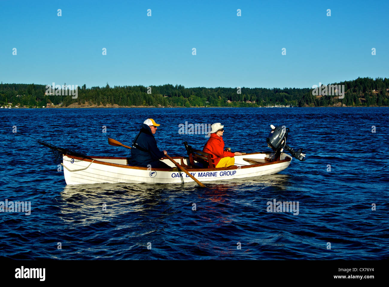 Pescatore femmina cerca di catturare un grande Salmone Chinook in piscina Tyee alla foce del fiume Campbell con guida tradizionale di canottaggio canotto Foto Stock