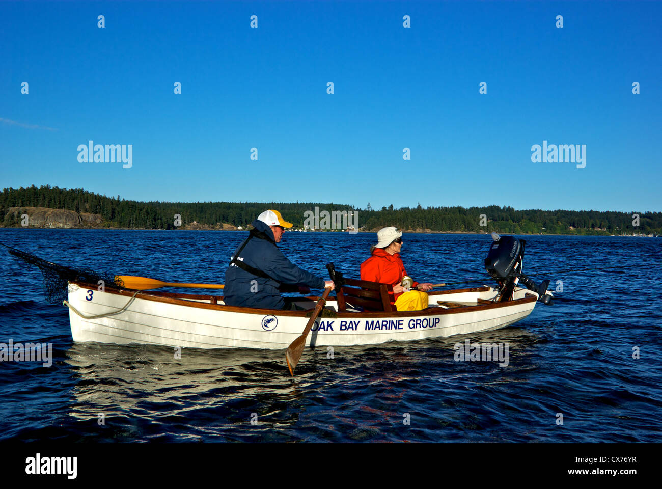 Pescatore femmina cerca di catturare un grande Salmone Chinook in piscina Tyee alla foce del fiume Campbell con guida tradizionale di canottaggio canotto Foto Stock