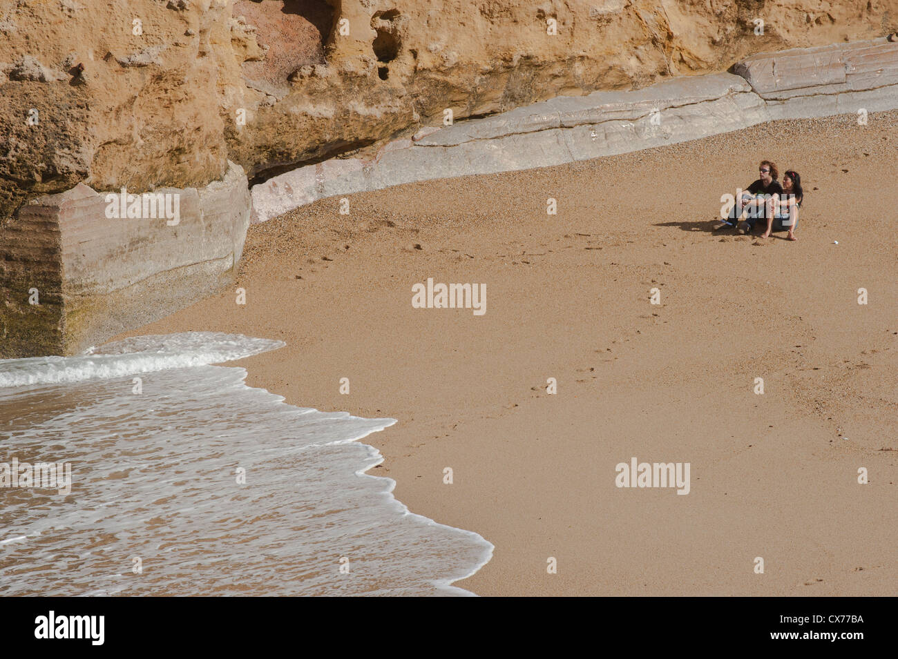 Un uomo e una donna sulla spiaggia di Port Vieux Biarritz con una marea dal mare Foto Stock