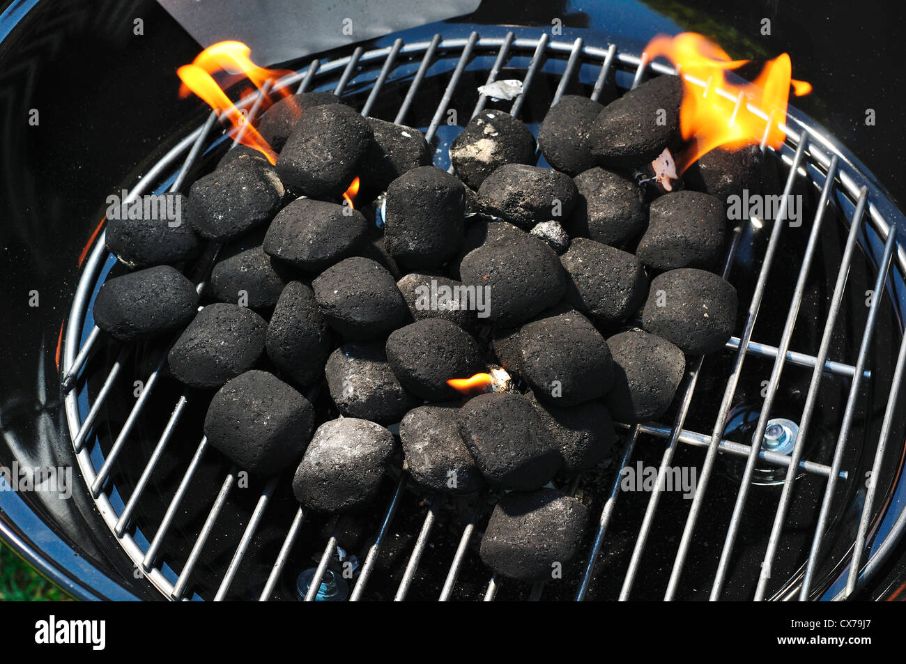 Bricchette di carbone a bruciare in un piccolo barbecue portatile Foto  stock - Alamy