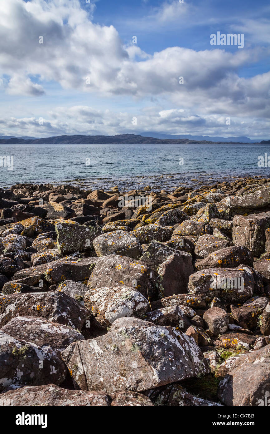 Rocce sulla riva del suono interno con l'isola di Raasay in background, Isola di Skye in Scozia Foto Stock