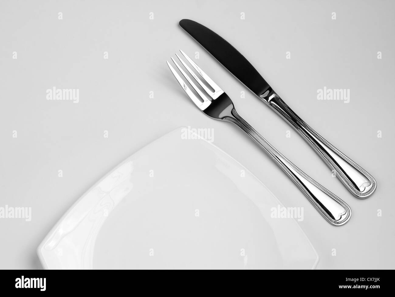 Posizionare l'impostazione per una persona. Coltello, piazza piastra bianca e la forcella. Foto Stock