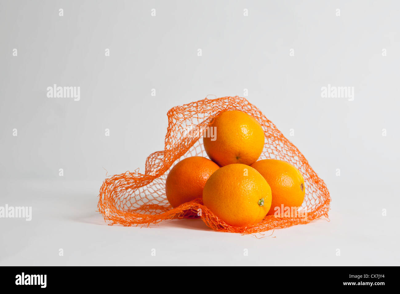 Un mucchio di arance in un aperto borsa a rete Foto Stock