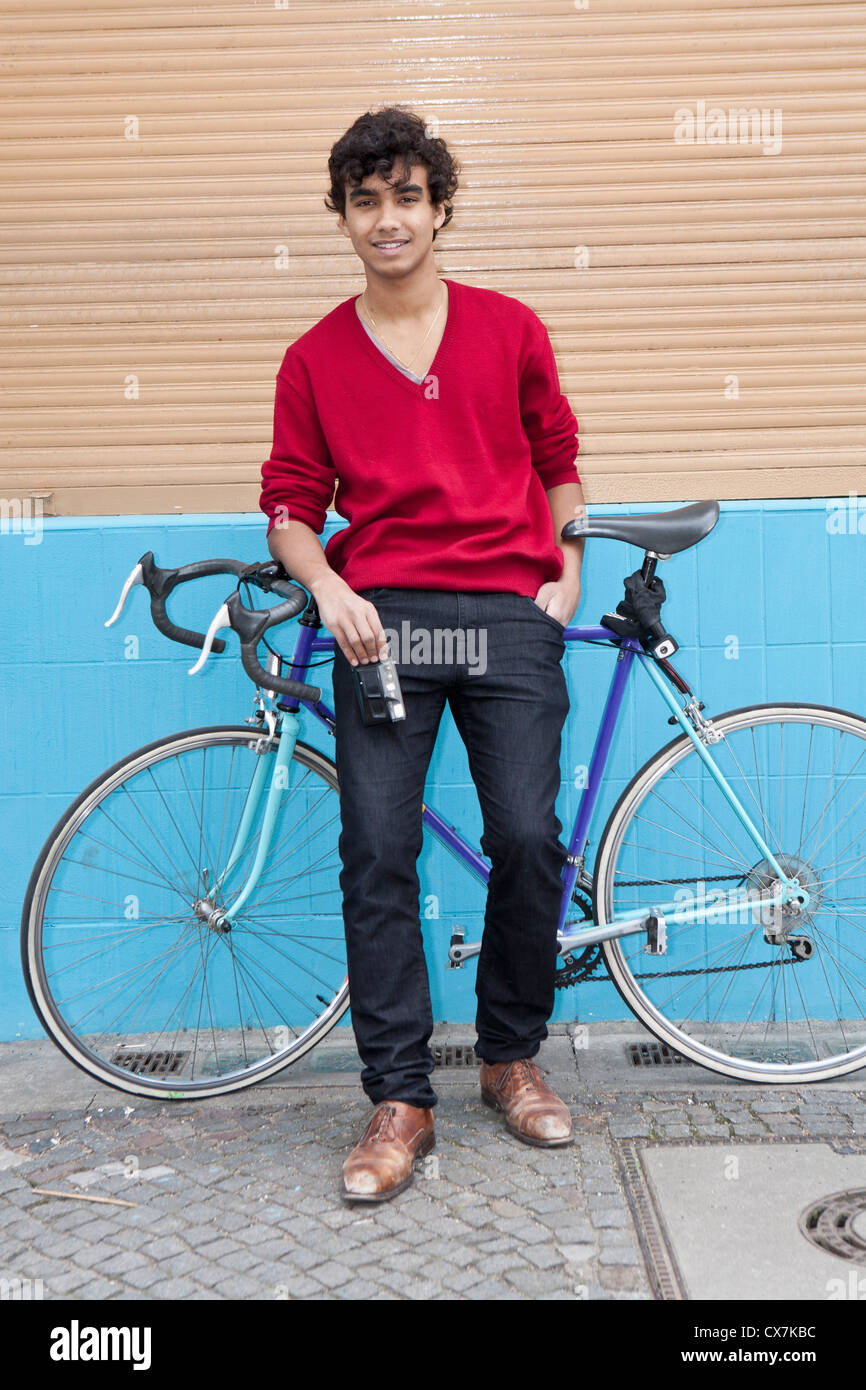 Guy appoggiata sulla bici tenere la fotocamera Foto Stock