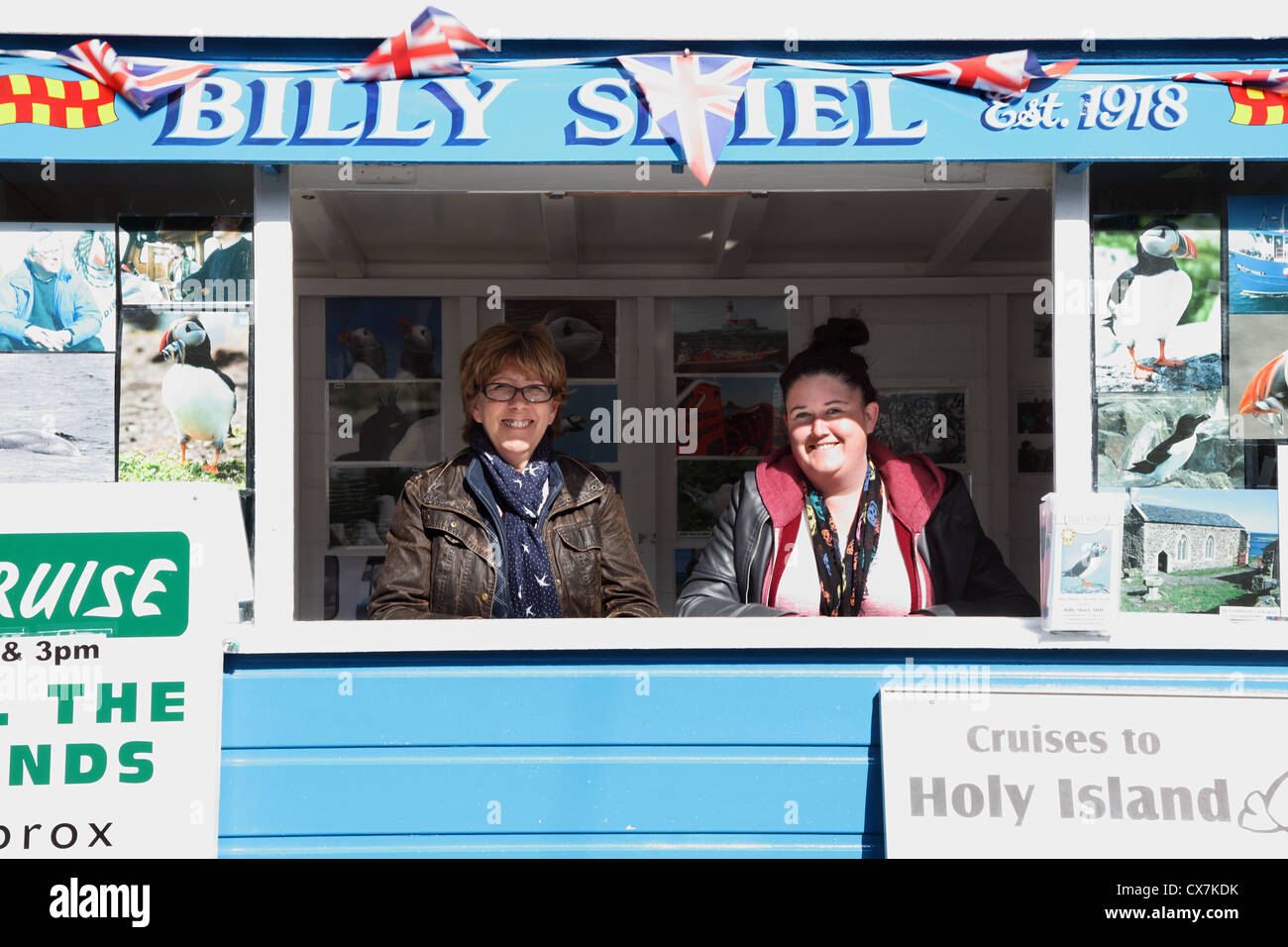 Due donne sorridenti all'interno di Billy Shiel's ticket booth vendita di gite in barca Seahouses, North East England Regno Unito Foto Stock