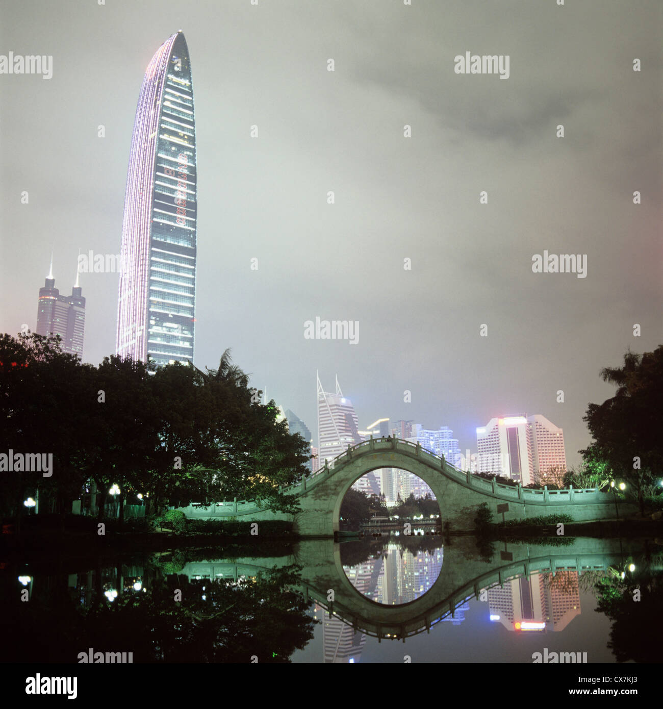Vista della città illuminata edifici attraverso acqua a notte, Shenzhen, Cina Foto Stock