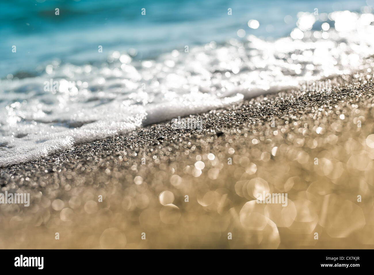 Spiaggia di sabbia e schiuma di mare macro con stretta sfondo di messa a fuoco Foto Stock