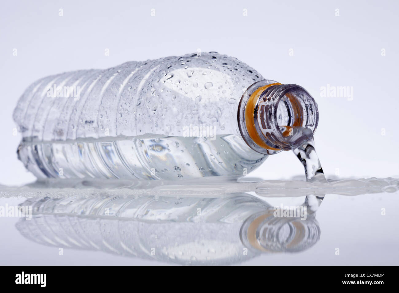 Una bottiglia d'acqua in plastica giacente sul suo lato, l'acqua fuoriuscita Foto Stock