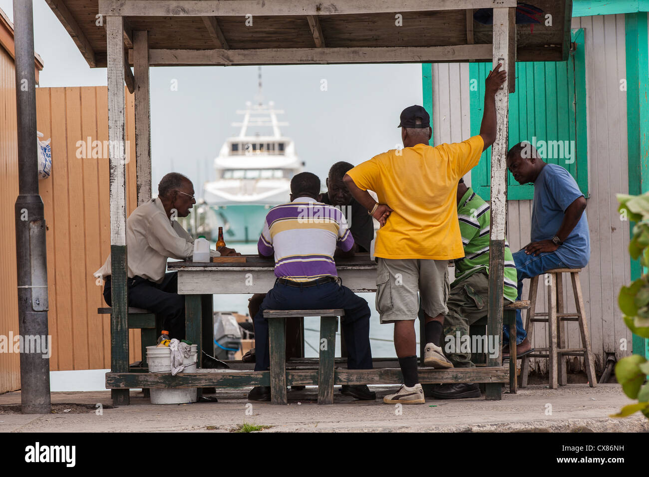 Gli uomini giocano a carte stradali di stallo alimentare a Potter's Cay a Nassau, Bahamas. Foto Stock