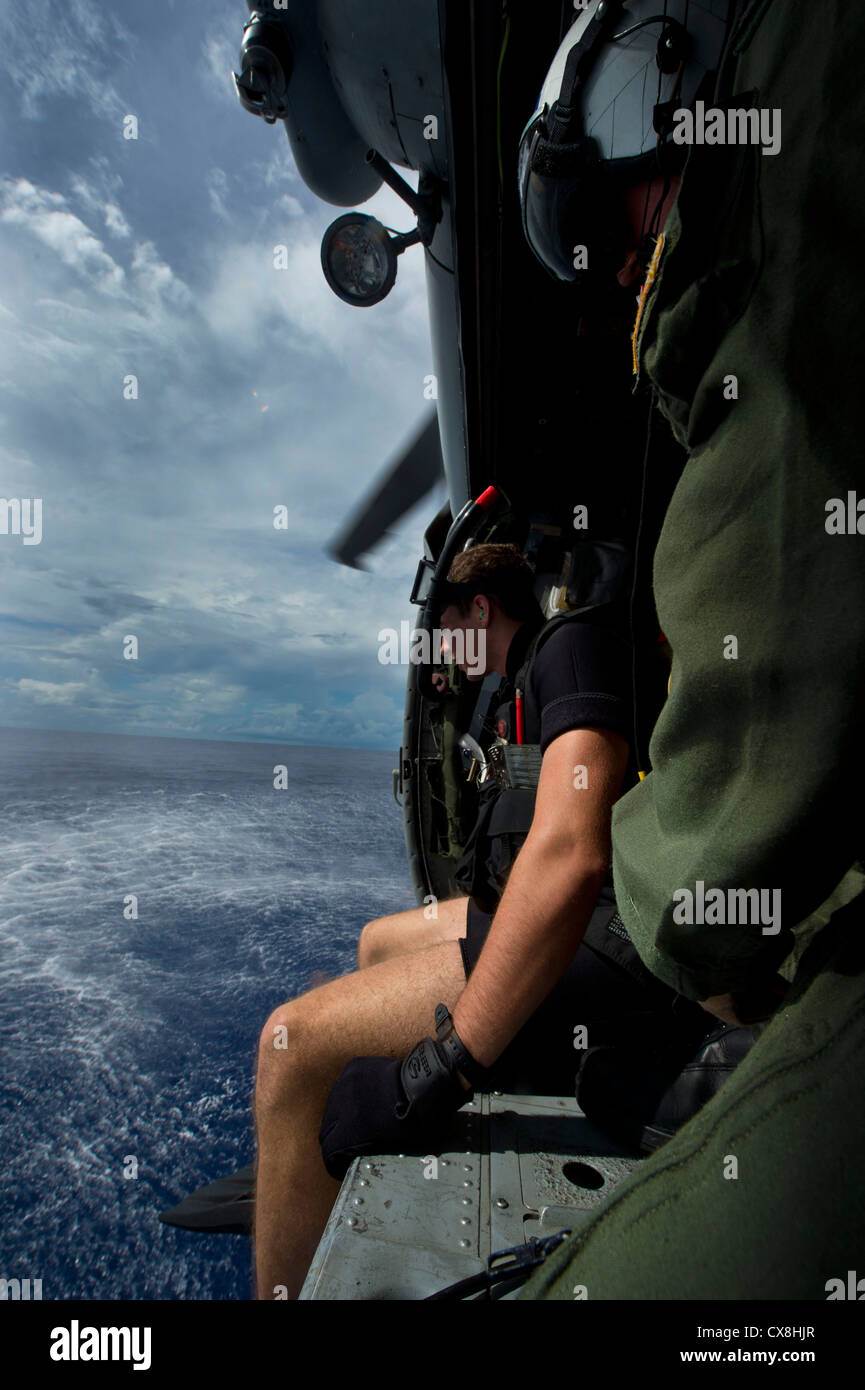 Mare delle Filippine (sept. 17, 2012) aircrewman navale di terza classe Robert Sherman, sinistra e naval aircrewman 2a classe william branson, simulare operazioni di ricerca e salvataggio tecniche da un MH-60s sea hawk elicottero, assegnato al mare in elicottero combat squadron (HSC) 25. HSC 25 è attualmente in corso con la distribuita Amphibious Assault nave USS bonhomme richard (LHD 6), il conduttore della nave il solo distribuita anfibio gruppo pronto. Foto Stock