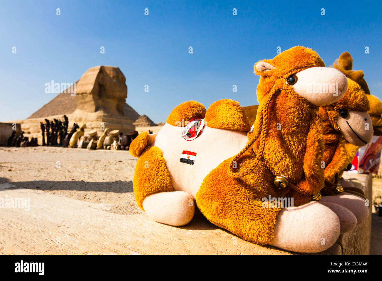 Camel peluche negozio di souvenir sul display con la Sfinge di Giza in background. Giza, il Cairo, Egitto Foto Stock