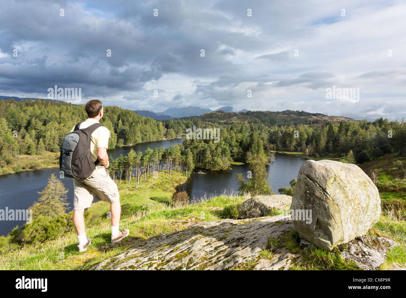 Backpacker si affaccia sul Tarn Hows camminare vicino a Hawkshead nel Lake District inglese, REGNO UNITO Foto Stock