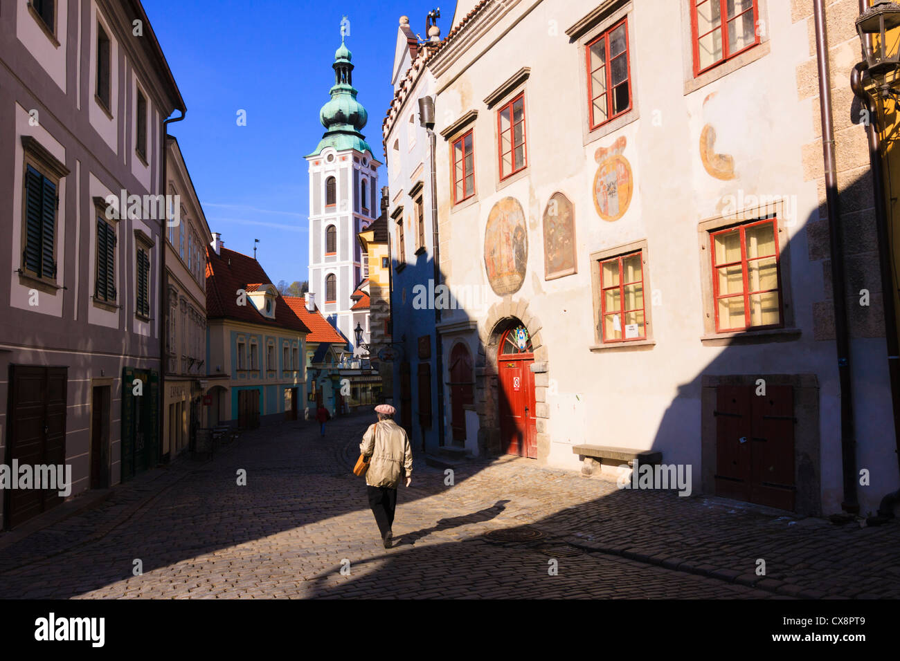 La donna a piedi attraverso una strada solitaria all'alba a Cesky Krumlov, Repubblica Ceca Foto Stock