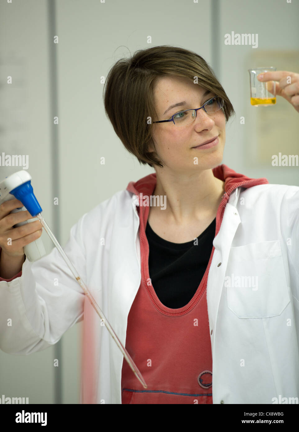 Giovane donna preparare soluzioni in laboratorio Foto Stock